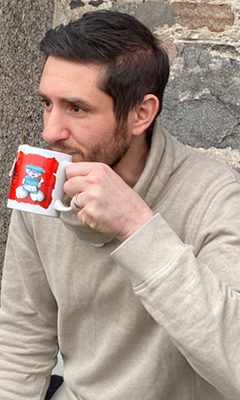 Daniel, een van de gastgevers, drinkt uit een mok