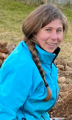 Sarah, een van de gastgevers, buiten in een blauwe jas